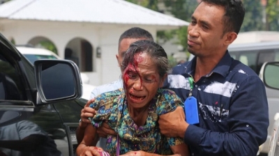 Jornalista Diariu INDEPENDENTE ajuda hela ferik ida ne'ebe hetan tiru husi Polisia Task Force, tersa (3/4) iha Parlamentu Nasional oin. Foto INDEPENDENTE.