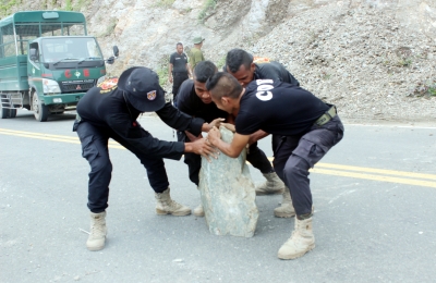 LIMPEZA: Forsa - FFDTL no PNTL suru hela rai no fatuk ne'ebé monu taka metin estrada parte foho Karimbala, Segunda (30/01). FOTO: MEDIA/MPIE